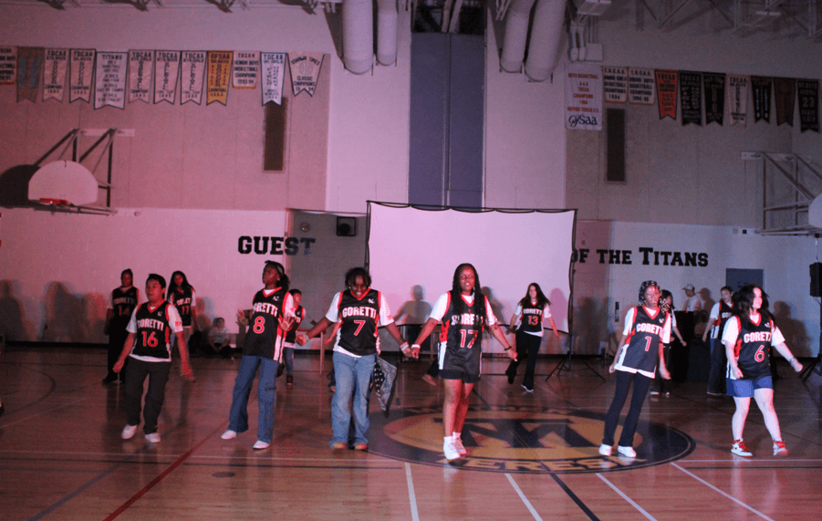 Students in matching Goretti jerseys performing together in a school gym