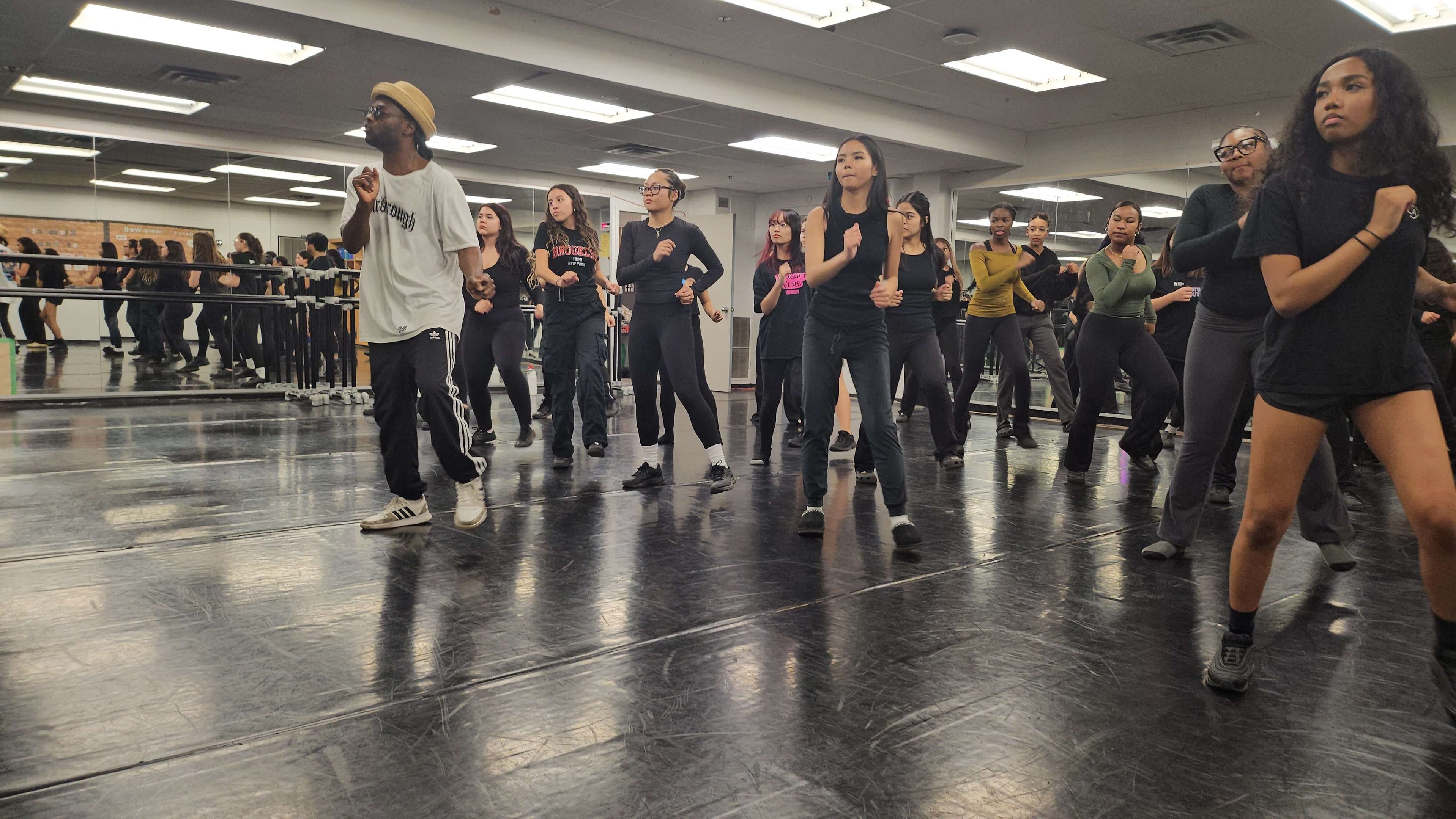 An H4 mentor leading students through a dance class